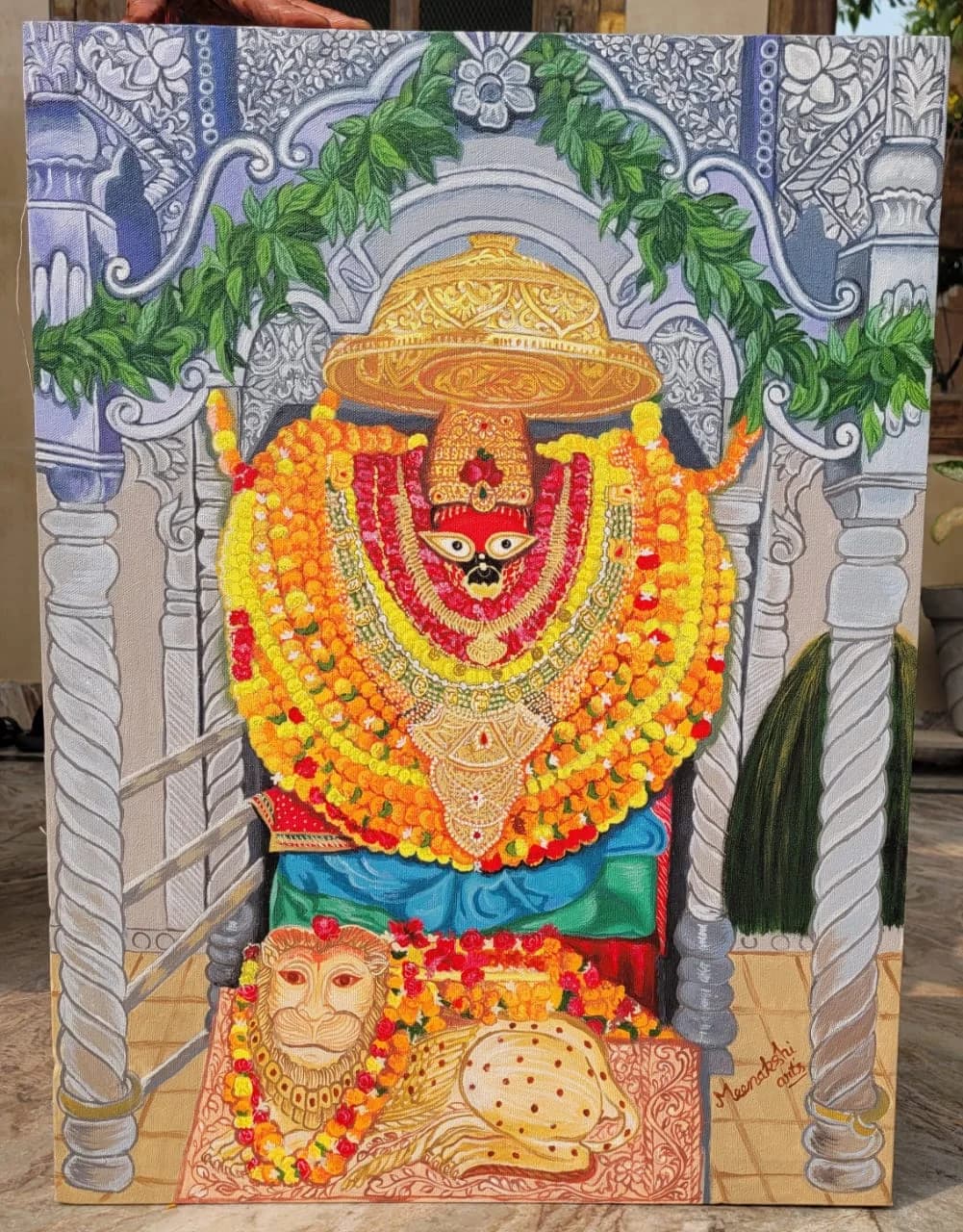 Marigold-garlanded deity idol beneath a temple arch