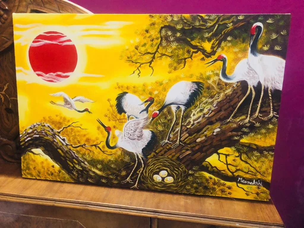 Cranes resting on a branch at golden sunset